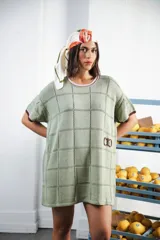 Vestido corto negro con patrón calado cuadrado, cuello redondo y mangas cortas con terminaciones a contratono en blanco.