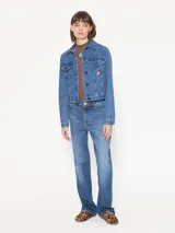 Campera de jean azul de calce estándar con bordados y parches de figuras emblemáticas del artista Edgardo Giménez.
