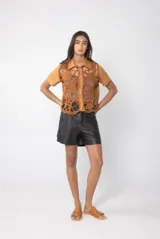 Camisa color crema de lino con pechera de crochet con motivos marinos y mangas cortas.