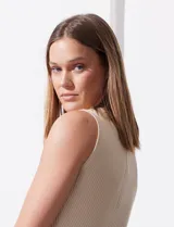 Musculosa color beige en tejido acanalado, marca Tahari, con cuello a la base y sin mangas.