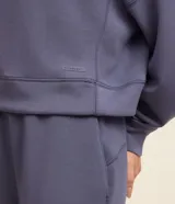 Buzo deportivo femenino confeccionado en microfibra color azul, con cuello redondo, mangas raglán largas y recortes.