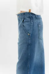 Pantalón de jean azul de pierna ancha y tiro medio, con cinco bolsillos y pespuntes a contratono.