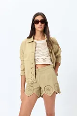 Short blanco de algodón con bordado calado y terminación festoneada en el borde inferior.