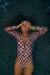 Enterito de lycra Ecocean reciclada con protección SPF 50, con mangas largas y cierre frontal. Estampa estilo 60s en el cuerpo y mangas rosadas con estampado de cactus.