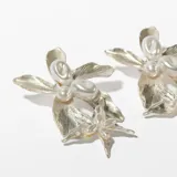 Aros colgantes con forma de flor plateada con perlas.
