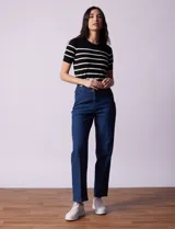 Jean elastizado de corte recto, color azul denim, con pretina con pasadores, botón y cierre. Tiene tres bolsillos delanteros y dos bolsillos traseros.