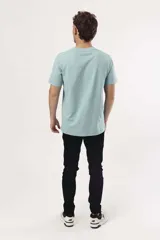 Remera de algodón color naranja claro con cuello redondo y manga corta. Presenta un pequeño estampado gráfico de temática playera en el pecho izquierdo.