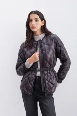Campera de nylon color berenjena con relleno de pluma, corte regular, cierre doble en delantero y bolsillos. Cinturón elástico gofrado en la espalda y mangas largas con elástico en puños.