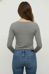 Remera negra de manga larga, confeccionada en algodón y elastano, corte ajustado al cuerpo y cuello redondo.