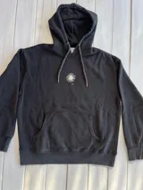 Hoodie negro con efecto gastado, corte oversize, capucha y puños acanalados. Estampado en la espalda con dos palmeras y un sol.
