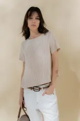 Blusa de lino color beige con rayas verticales negras, corte recto, escote redondo y mangas cortas.