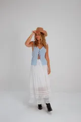 Top tejido de punto color celeste claro, sin mangas, con escote pronunciado en V y cierre frontal mediante lazos anudados. Presenta un patrón texturizado de cuadros.