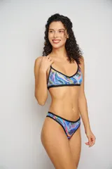 Conjunto de bikini con estampado animal print multicolor, compuesto por un corpiño triangular con tirantes finos y una bombacha tipo colaless con tiras finas ajustables en los laterales.