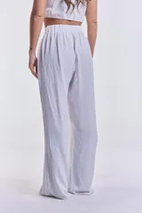 Pantalón blanco de corte palazzo con cintura alta y elástica.