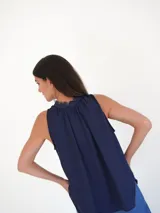 Musculosa color verde militar con cuello redondo y lazo marrón en el escote.