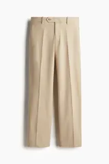Pantalón de vestir color beige, de corte recto, con pliegues frontales, bolsillos laterales y traseros con botón.