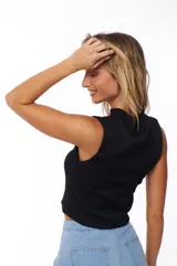 Top negro sin mangas con cuello alto y textura acanalada.