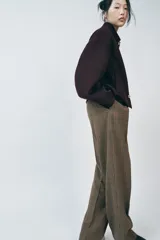 Cazadora corta color borgoña confeccionada en hilatura con lana. Tiene cuello solapa, manga larga, bolsillos delanteros y cierre frontal con botones metálicos dorados en relieve.