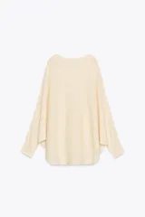 Sweater color crema de tejido de punto liso, con cuello barco y mangas anchas que se estrechan hacia la muñeca.