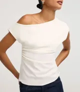 Blusa de crepé color blanco, con escote asimétrico, manga corta y drapeado lateral.