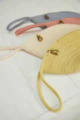 Sobre de mano color beige, confeccionado en soga de algodón trenzada, con forma irregular y cierre con broche de bronce.