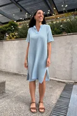 Vestido tejido celeste con escote en V, mangas cortas y aberturas laterales.