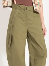 Pantalón negro de poplin 4way con lazo en la cintura, bolsillos ojales en delantero y espalda, pinza a la altura de la rodilla que le da una forma curvada, acceso mediante broche pantalonero, cierre y botón interno a tono de tela. Broches en el ruedo permiten ajustarlo.