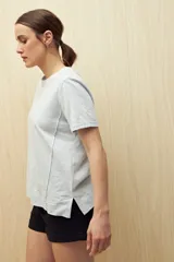 Remera blanca de algodón liviano con textura sutil, manga corta y cuello redondo.