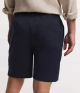 Bermuda masculina color beige de sarga, con cintura elástica ajustable con cordón y bolsillo trasero.