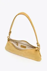 Bolso de hombro color mostaza, confeccionado en gamuza. Tiene asa corta, cierre superior con cremallera y herrajes dorados.