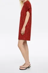 Minivestido rojo con estampado animal print en tonos marrones, de corte recto, cuello redondo y mangas cortas.