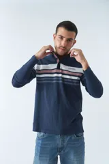 Remera cuello polo de manga larga color beige con rayas horizontales en verde, azul y blanco.