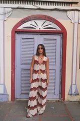 Pantalón de punto acanalado color crudo con diseño de ondas en marrón y bordó. Tiro alto con cordón ajustable en la cintura y corte palazzo.