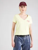Remera color amarillo claro con cuello en V y estampado de cerezas rojas con moño.