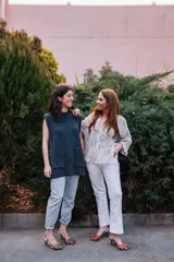 Zapato de tacón destalonado con estampado animal print en tonos naranja y marrón, con lazo doble en la parte delantera y tira trasera con hebilla. Tacón cuadrado de 2,5 cm y suela de cuero.