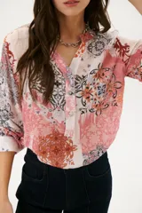 Camisa de manga larga con estampado abstracto en tonos rosa, blanco y negro.