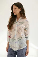 Camisa beige de manga 3/4 con cuello mao y cierre frontal con botones. Presenta un estampado con motivos marinos en tonos azules, verdes y marrones.
