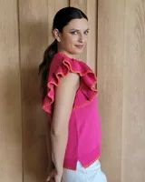 Musculosa blanca de punto con cuello redondo y mangas con volados.