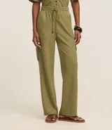 Pantalón largo color verde oliva, de corte pijama, confeccionado en malla orly. Presenta cintura elástica con lazo, bolsillos laterales tipo cargo y corte fluido.