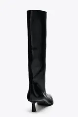 Bota de caña media color negro, de cuero sintético, con punta fina y taco kitten.