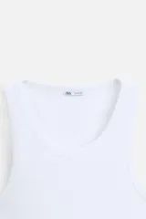 Musculosa negra ajustada al cuerpo, con cuello redondo y sisas amplias.