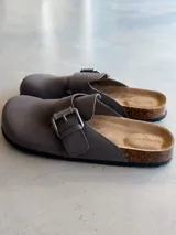 Zuecos grises con hebilla metálica ajustable y plantilla anatómica de corcho.