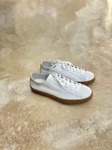 Zapatillas bajas de cuero negro con cordones y suela de goma color caramelo.