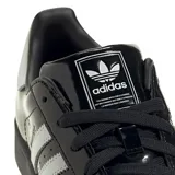 Zapatillas Adidas Superstar II color negro charol con las tres tiras laterales blancas y contrafuerte blanco.