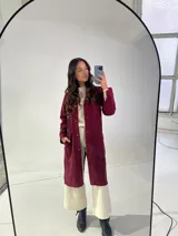 Tapado largo de jeans color bordó con cuello camisero, cierre frontal con botones a presión, mangas largas con puños abotonados, bolsillos laterales y bordado floral en la espalda.