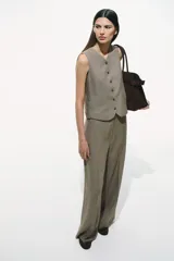 Pantalón de vestir color gris topo, de tiro alto, corte amplio y largo hasta el tobillo. Confeccionado en tejido liviano de mezcla de lino y viscosa.