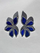 Par de aros con forma de flor azul de terciopelo, contorneada con strass y cierre a presión de acero inoxidable.