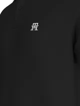 Chomba negra de algodón orgánico con cuello clásico, cartera de dos botones y logo de monograma TH bordado en blanco en el pecho.