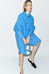 Abrigo amplio de Zara Woman Collection confeccionado en hilatura con mezcla de lana. Tiene cuello solapa, manga larga, bolsillos delanteros, forro interior a contraste y cierre frontal con botones.