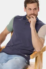 Remera polo de piqué combinada en azul, verde y beige.